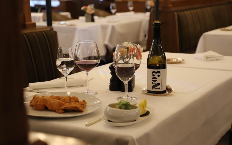 Weinservice für die Gastronomie Weinservice im Restaurant mit gedecktem Tisch, Weingläsern und Wein